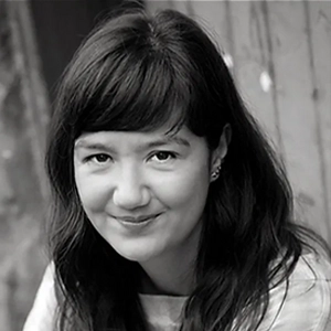 Producer Catryn Ramasut, with long dark hair and a fringe, in a black-and-white portrait.