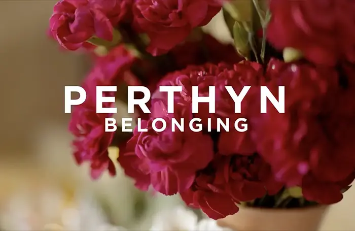 Thumbnail for the documentary Perthyn (Belonging), showing its subject by a Buddhist shrine.